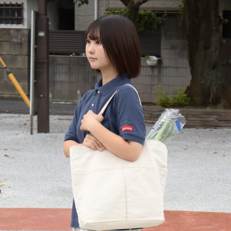 買い物袋を持って歩くヘルパー